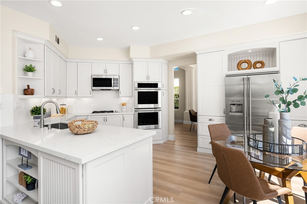 36 Mallorca Lake Forest, CA 92610 - Photo 28 of 64 a kitchen with stainless steel appliances a table chairs refrigerator and microwave
