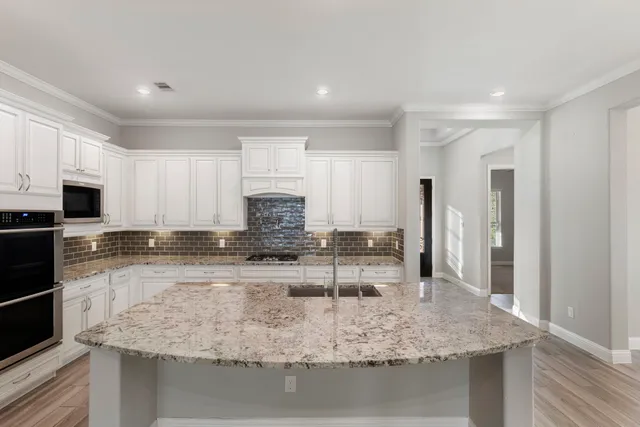 a kitchen with kitchen island granite countertop a sink stove and refrigerator