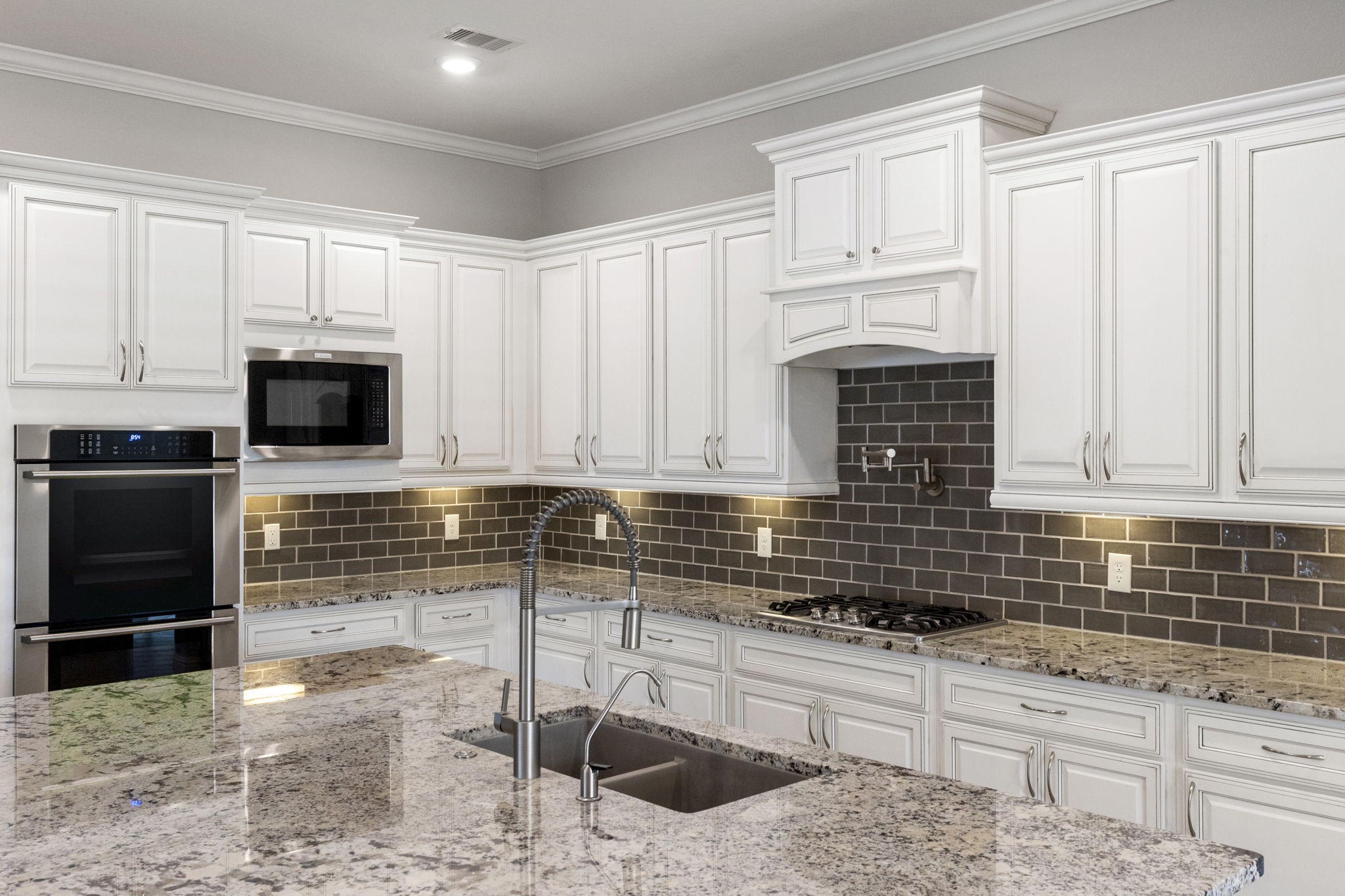 18855 Collins View Drive New Caney, TX 77357 - Photo 12 of 50 a kitchen with granite countertop a stove a sink and a microwave