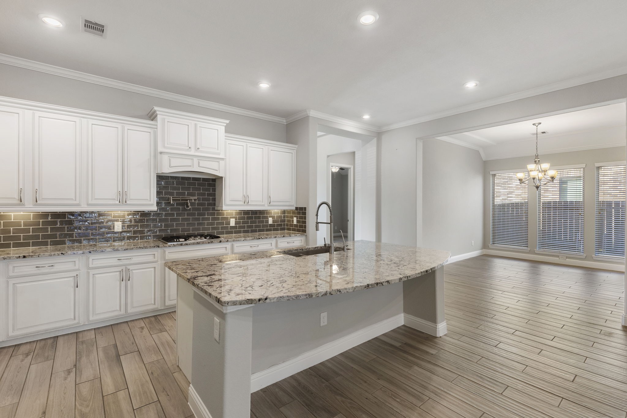 18855 Collins View Drive New Caney, TX 77357 - Photo 13 of 50 a kitchen with stainless steel appliances granite countertop a sink stove and white cabinets with wooden floor