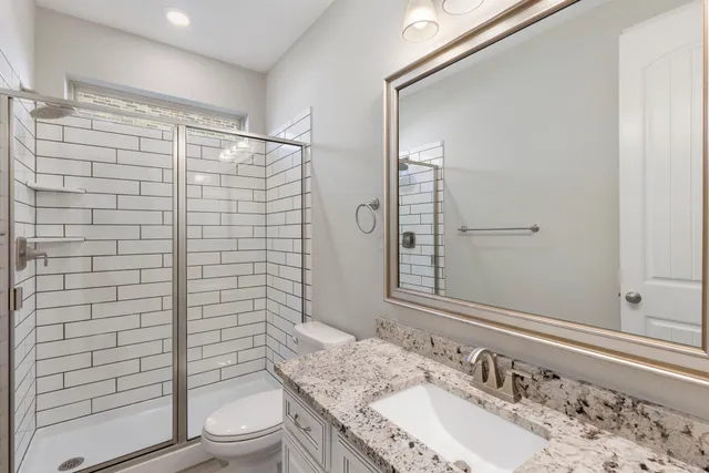 a bathroom with a granite countertop sink toilet and shower