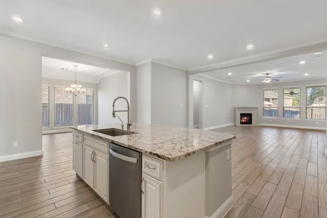 a kitchen with stainless steel appliances granite countertop a sink stove and wooden floor