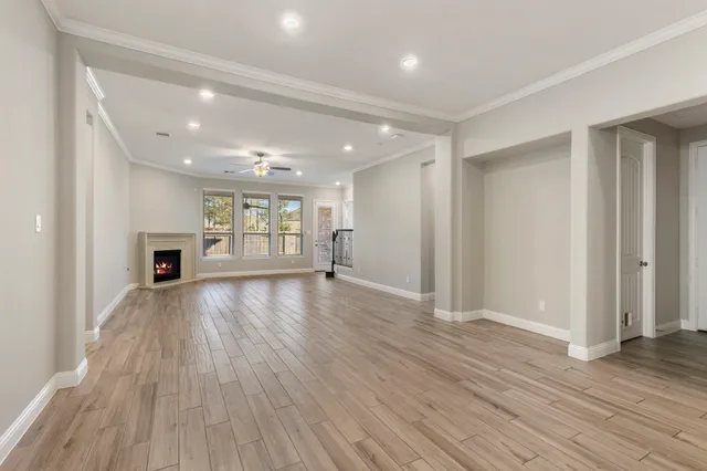 an empty room with wooden floor and fireplace