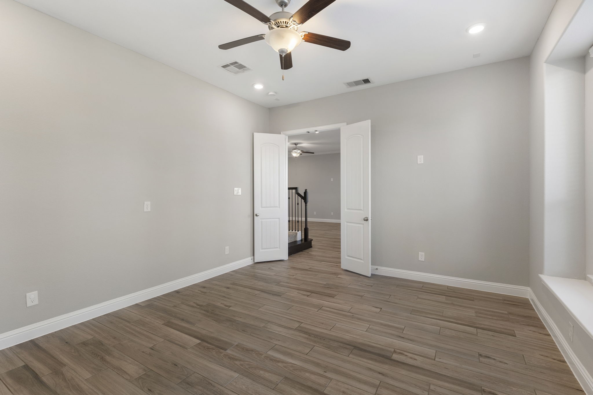 18855 Collins View Drive New Caney, TX 77357 - Photo 23 of 50 an empty room with wooden floor and a ceiling fan