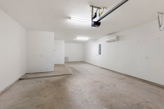 an empty room with a ceiling fan and windows