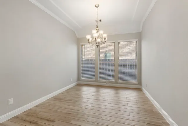 a view of wooden floor and chandelier in living room