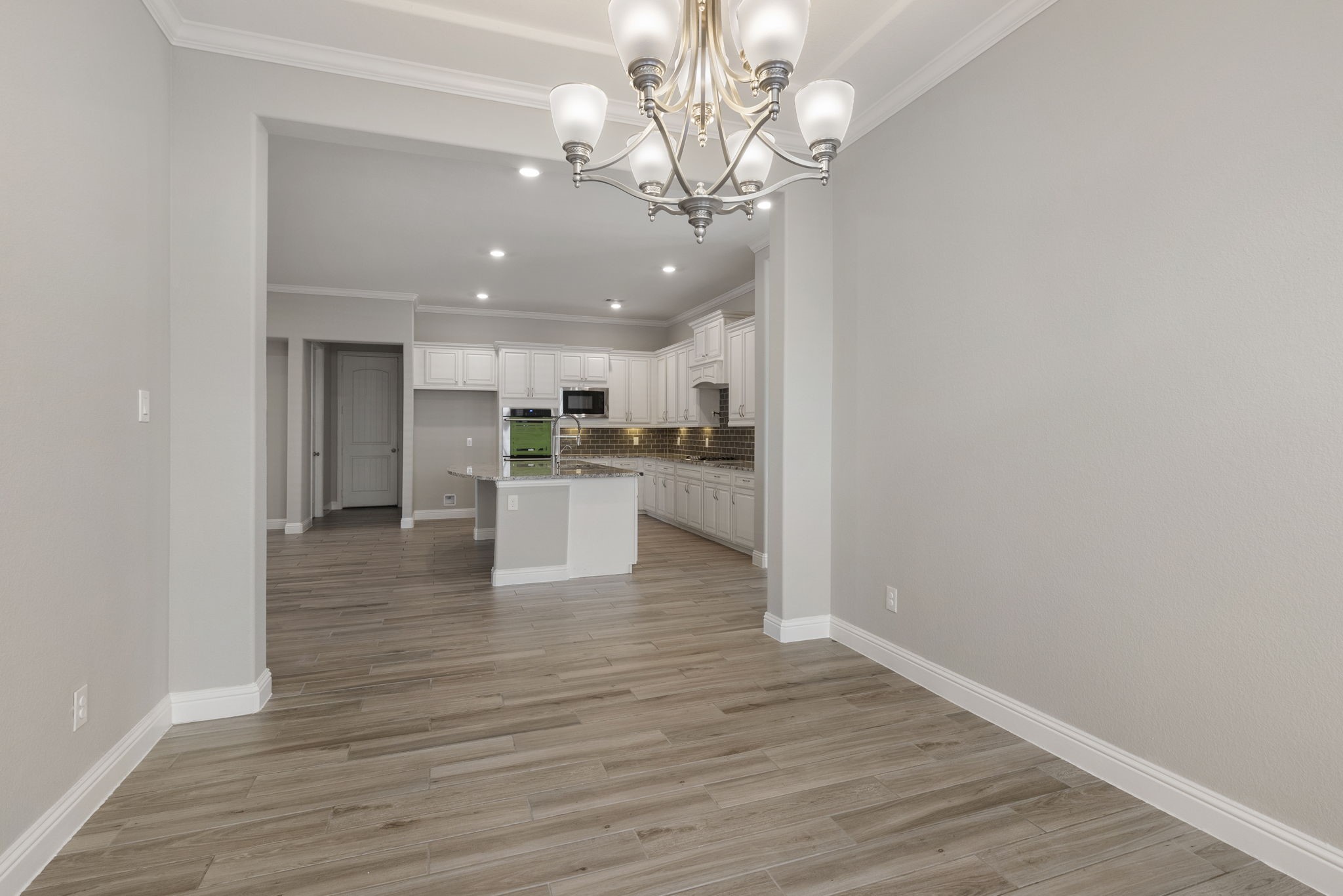 18855 Collins View Drive New Caney, TX 77357 - Photo 28 of 50 a view of an empty room and kitchen with wooden floor