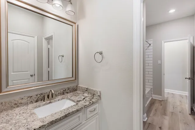 a bathroom with a granite countertop sink and a mirror