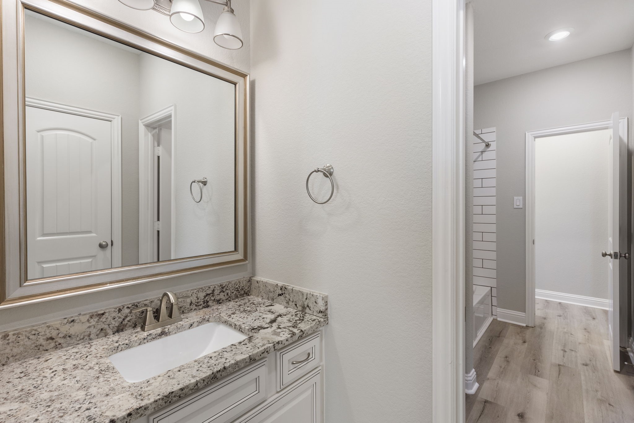 18855 Collins View Drive New Caney, TX 77357 - Photo 30 of 50 a bathroom with a granite countertop sink and a mirror