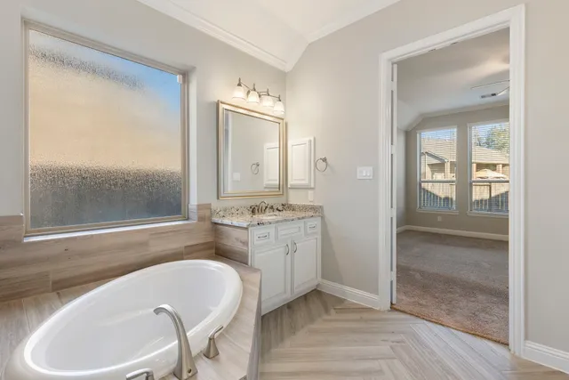a bathroom with a granite countertop tub sink and mirror