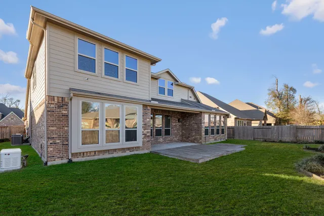 a front view of a house with yard and green space