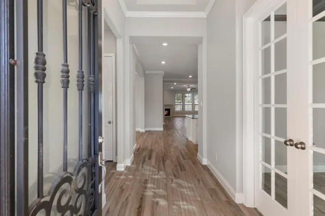 a view of a hallway with wooden floor and staircase