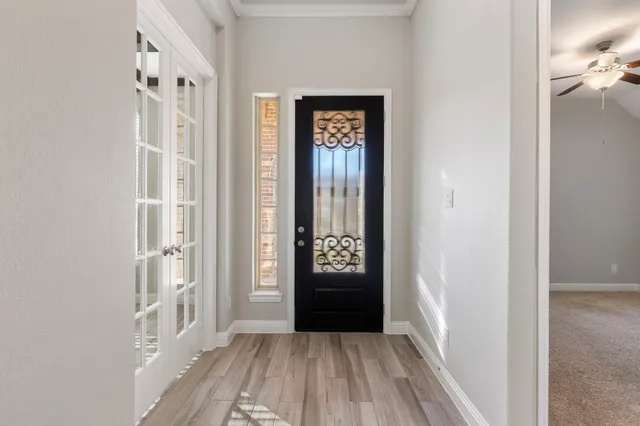 a view of a hallway with wooden floor and windows