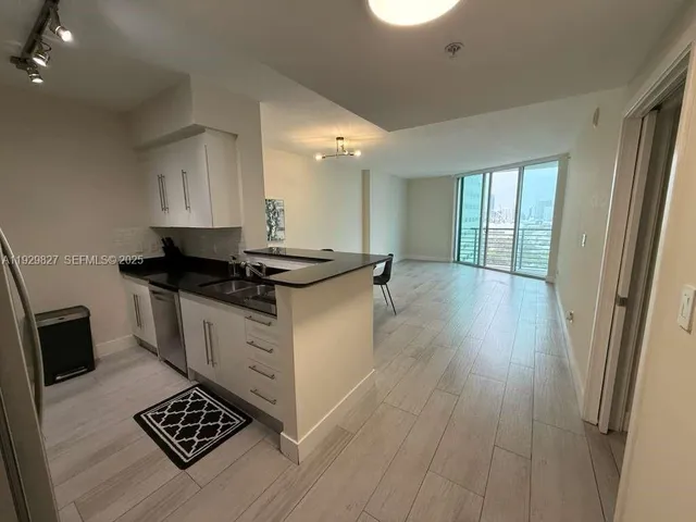 a kitchen with a sink and wooden floor