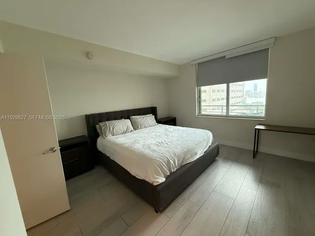 a bedroom with a bed lamp and window