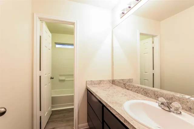 a bathroom with a granite countertop sink and a mirror