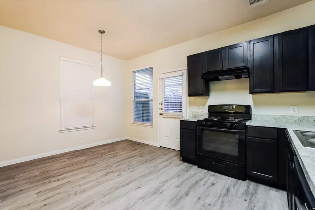 a kitchen with granite countertop wooden cabinets and black appliances