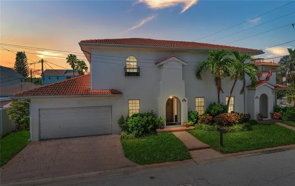 a front view of a house with a garden and plants