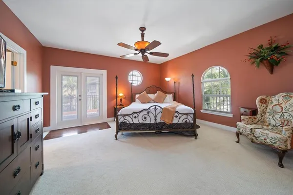a spacious bedroom with a bed and a chandelier