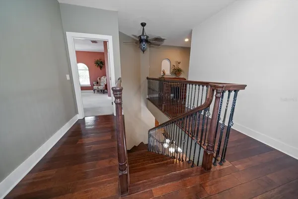 a view of a hallway with wooden floor and staircase