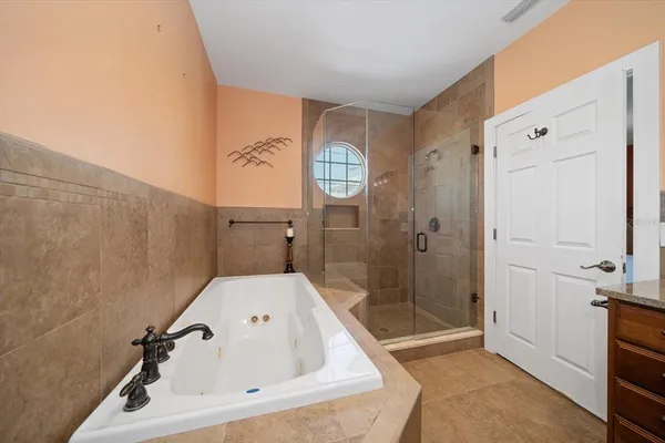 a bathroom with a tub a sink and mirror