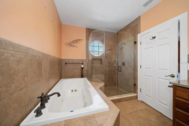 a bathroom with a tub a sink and mirror