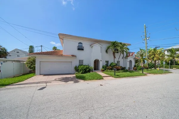 a front view of a house with garden and garage