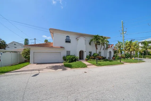 a front view of a house with garden and garage