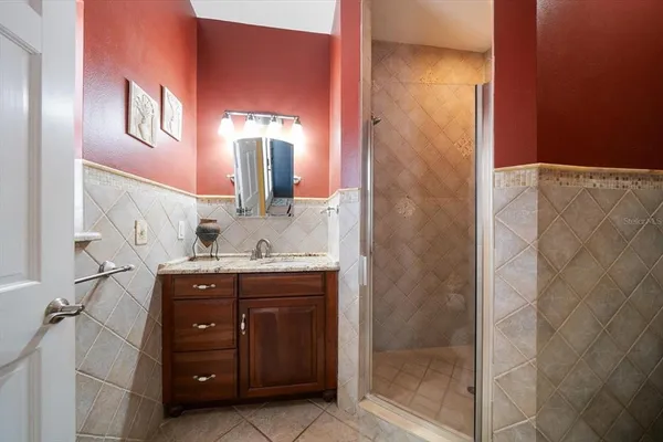 a spacious bathroom with a granite countertop sink a mirror and a shower