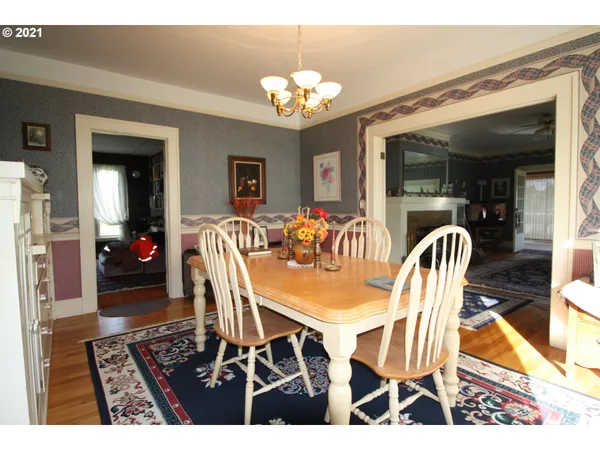 a dining room with furniture a chandelier and wooden floor