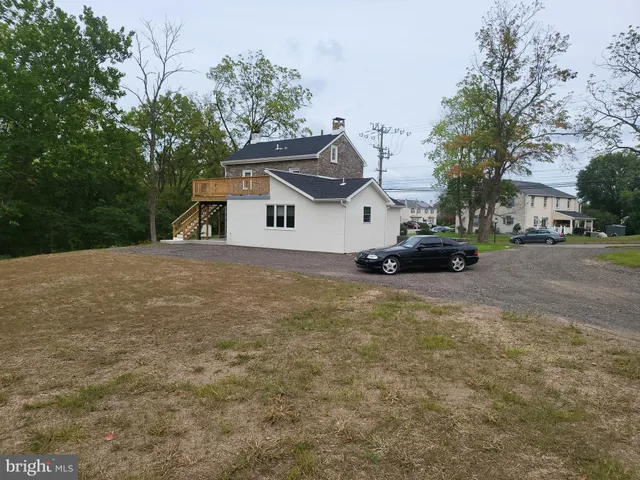 a white house that has a tree in front of it
