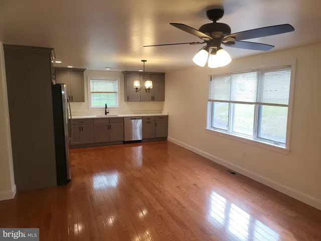 a view of a kitchen counter space wooden floor and ceiling fan