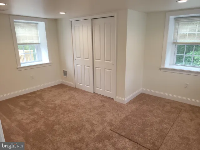 an empty room with windows and closet