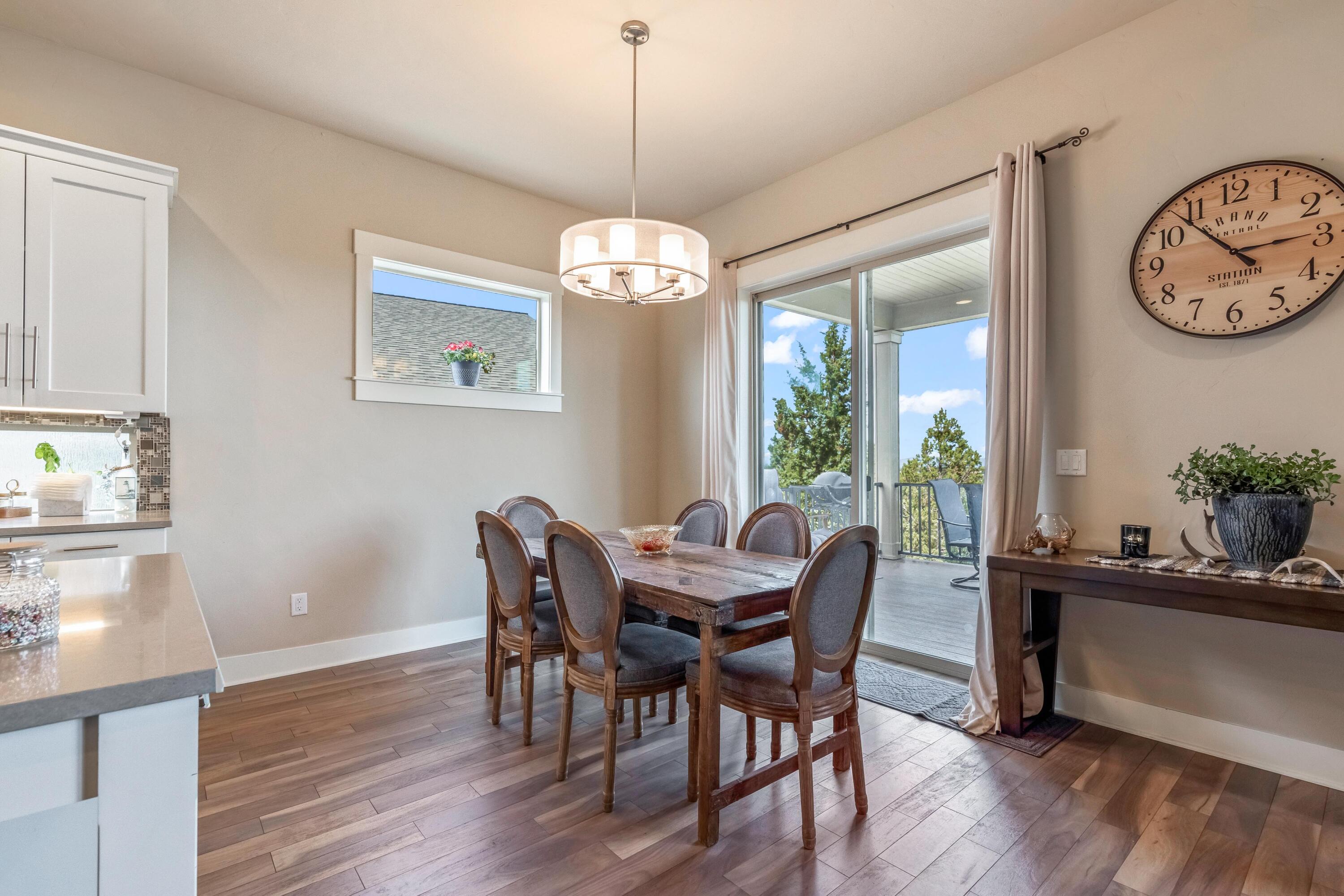2375 Northwest Majestic Ridge Drive Bend, OR 97703 - Photo 9 of 28 a dining room with wooden floor a chandelier a wooden table and chairs