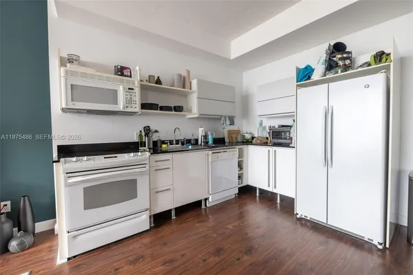 a kitchen with cabinets stainless steel appliances and wooden floor