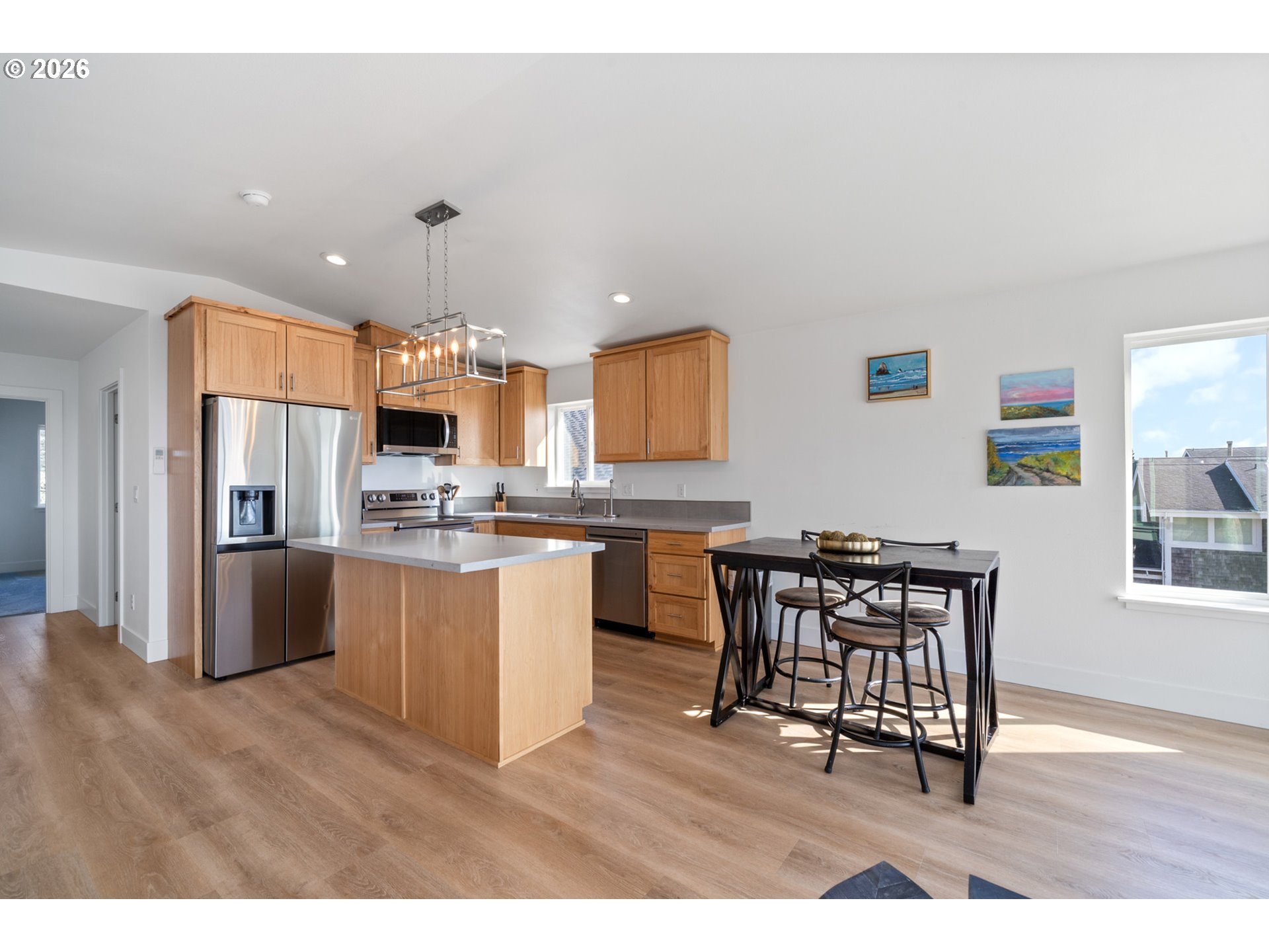 120 Reeder Street Tillamook, OR 97141 - Photo 15 of 41 a kitchen with stainless steel appliances kitchen island granite countertop a refrigerator a stove a sink a dining table and chairs with wooden floor