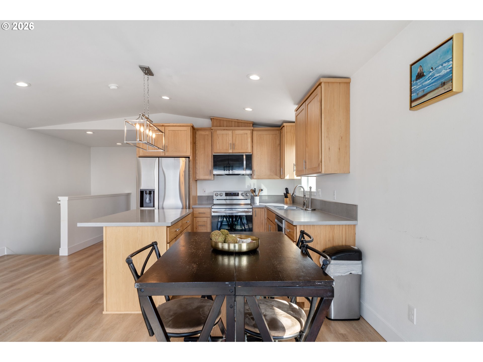 120 Reeder Street Tillamook, OR 97141 - Photo 17 of 41 a kitchen with a table chairs refrigerator and microwave