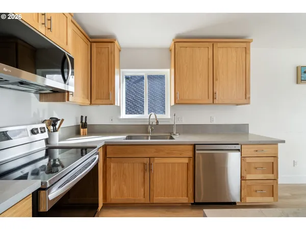 a kitchen with stainless steel appliances granite countertop a sink stove and microwave