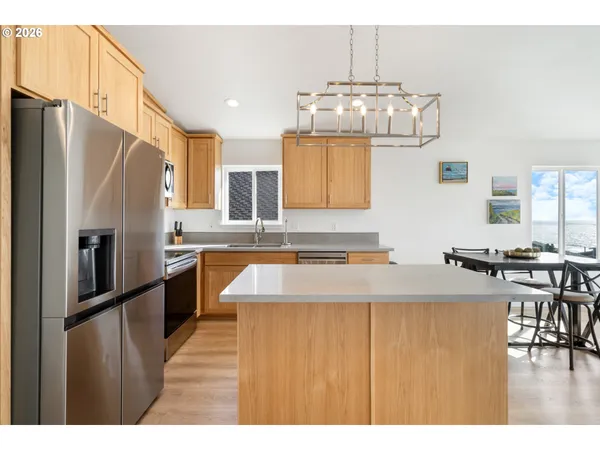 a kitchen with stainless steel appliances granite countertop a sink refrigerator and cabinets