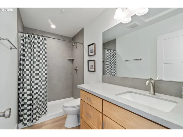 a bathroom with a sink a toilet a shower and a mirror