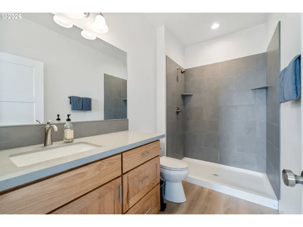 a bathroom with a double vanity sink toilet mirror and shower