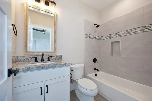 a bathroom with a granite countertop sink toilet and shower
