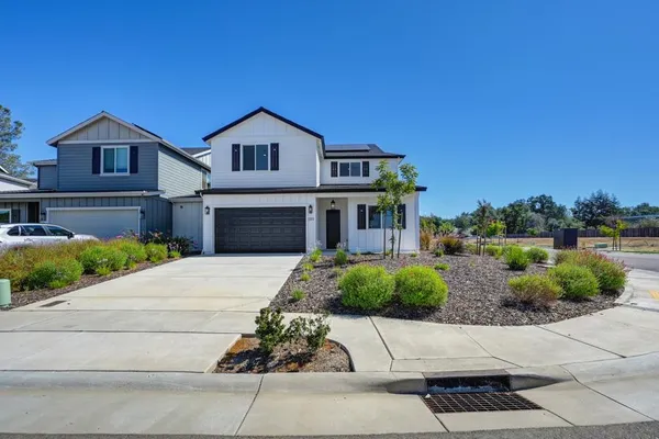a front view of a house with a yard and garage