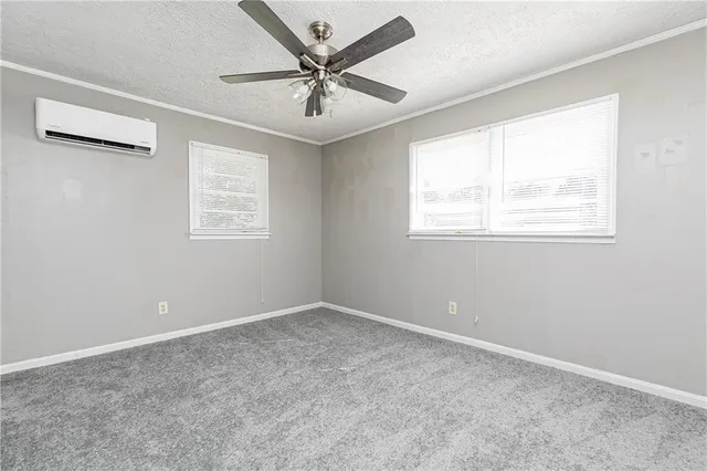 en empty room with windows and ceiling fan