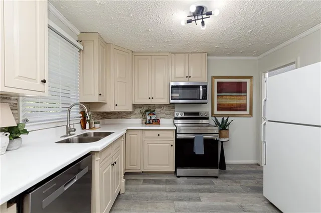 a kitchen with stainless steel appliances granite countertop a sink stove and refrigerator