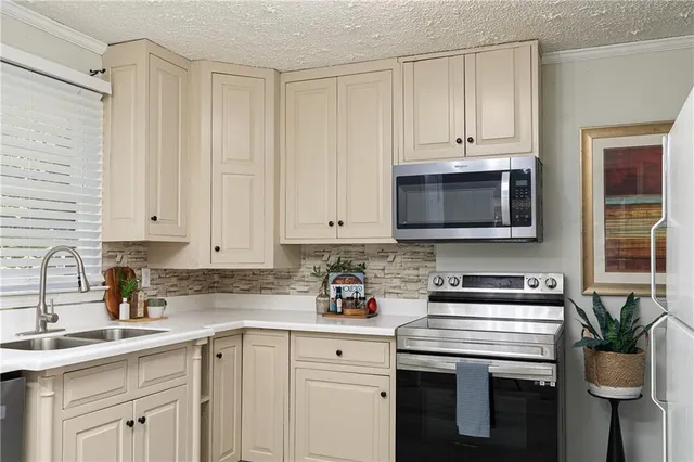 a kitchen with stainless steel appliances white cabinets and a sink