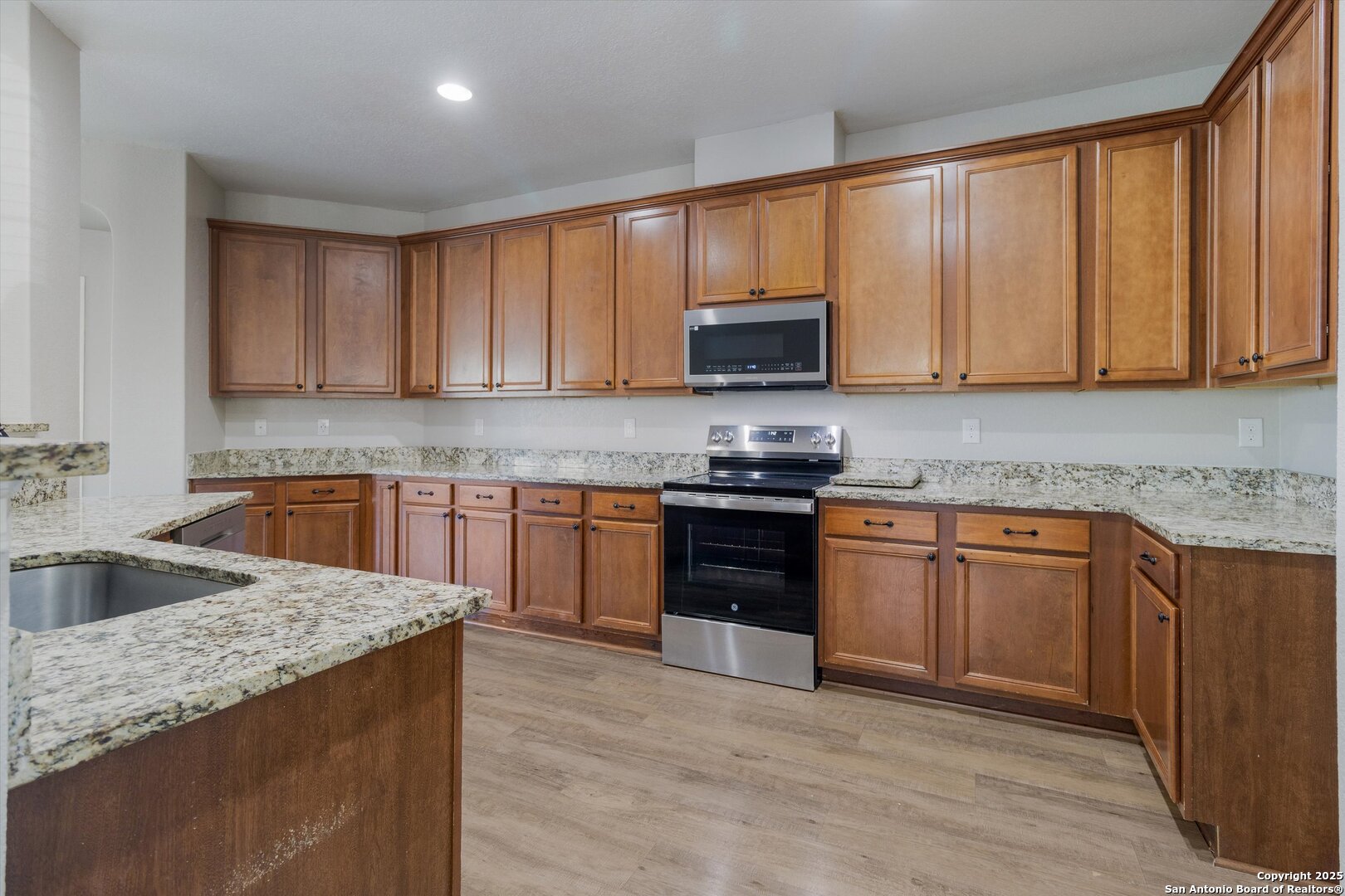 13506 Misty View San Antonio, TX 78245 - Photo 10 of 29 a kitchen with granite countertop a stove top oven sink and cabinets