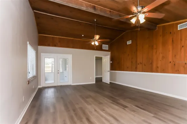 a view of a livingroom with wooden floor and a ceiling fan