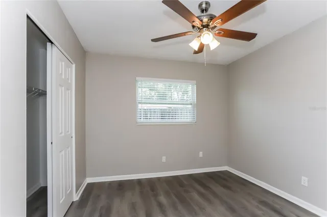 an empty room with windows and fan