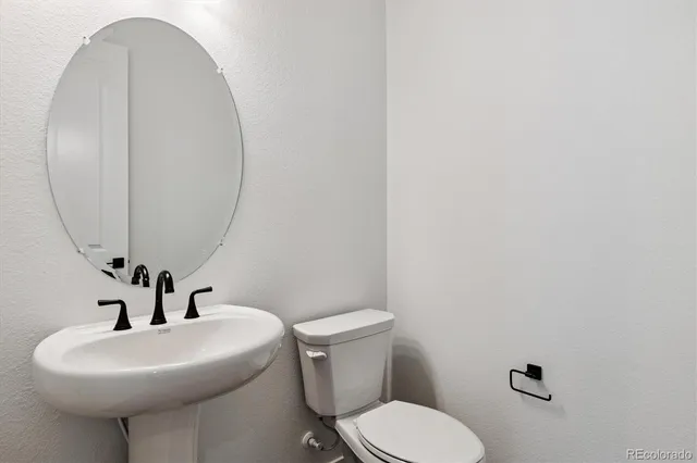 a bathroom with a sink mirror and toilet